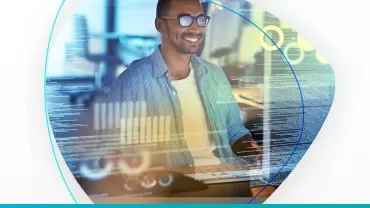 Hombre sonriente trabajando en computadora con gráficos digitales.