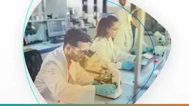 Científicos en laboratorio usando microscopio.