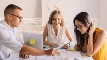 Grupo de personas colaborando en la mesa de una oficina.