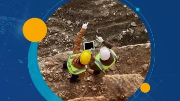 Vista superior de dos trabajadores de construcción revisando una tableta.