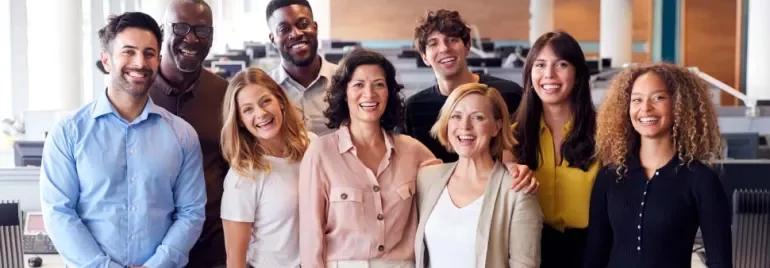 Grupo de personas sonriendo en una oficina moderna.