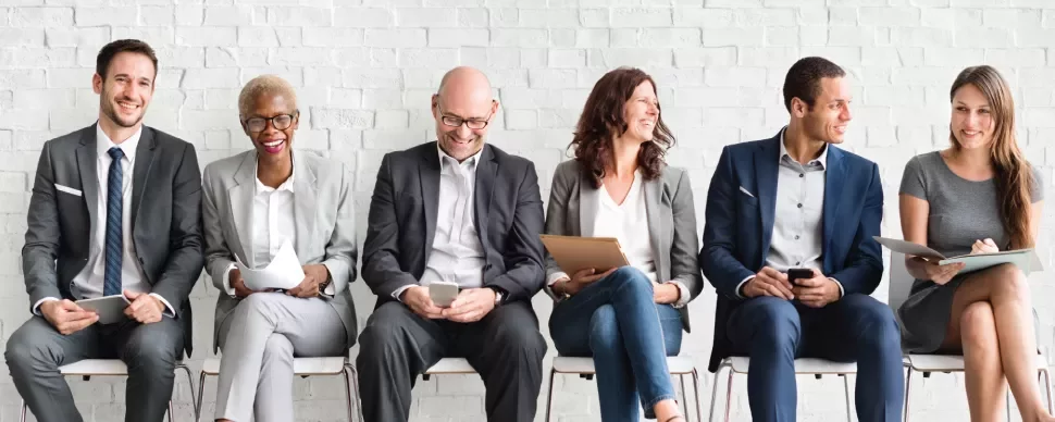 Grupo de personas sentadas en una sala de espera.