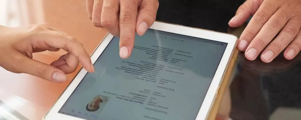 Personas revisando un documento en una tablet.