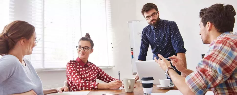 Personas en una reunión con una pizarra detrás.