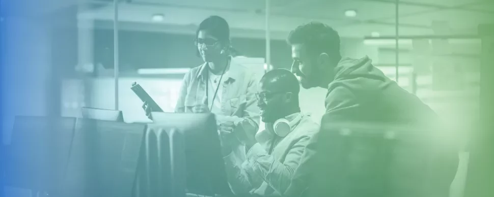 Tres personas colaborando frente a una pantalla de computadora.
