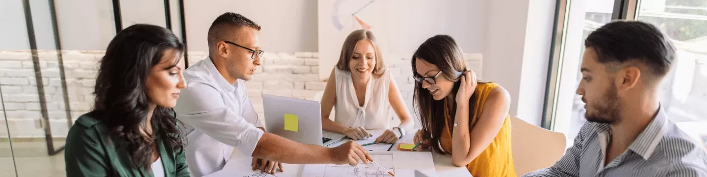 Grupo de personas colaborando en la mesa de una oficina.