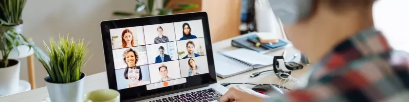 Persona en videollamada grupal desde laptop.