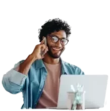 Profesional trabajando en computadora portátil y atendiendo una llamada telefónica.