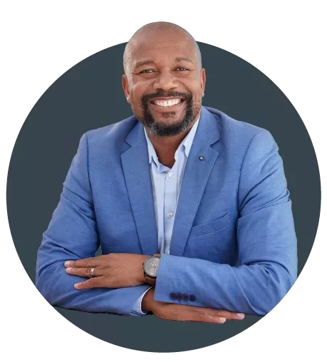 Profesional de Page Executive con atuendo formal, vistiendo saco azul y camisa blanca en un entorno corporativo.