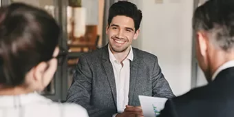 Hombre sonriendo durante una reunión de trabajo.